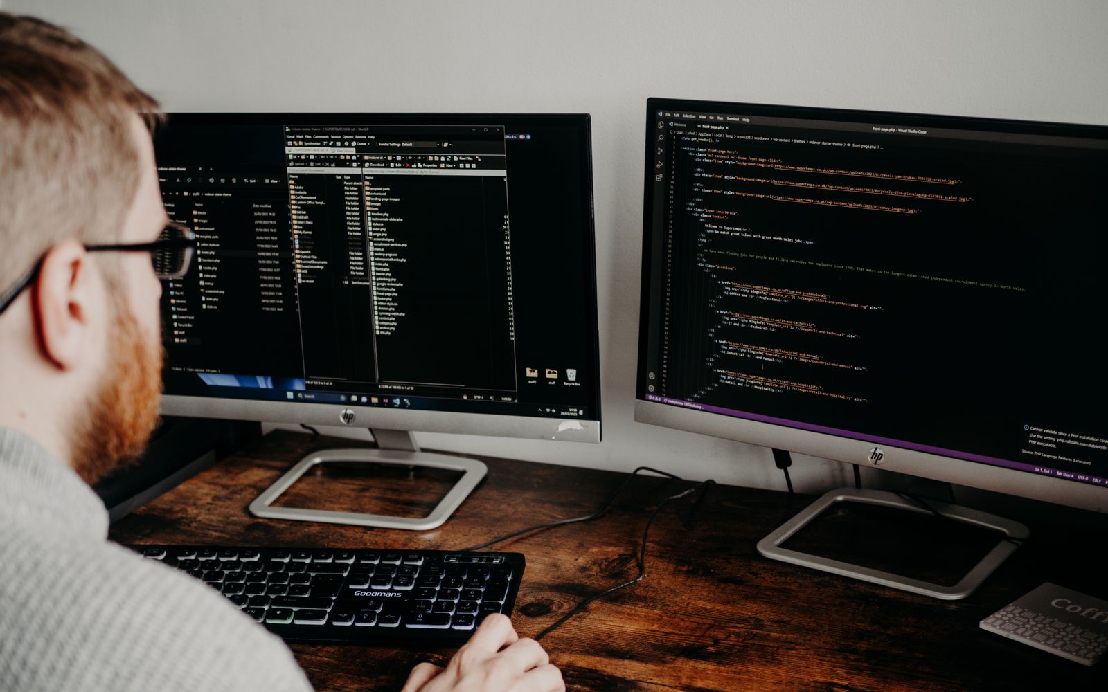 Desenvolvedor programando em dois monitores em escritório em casa