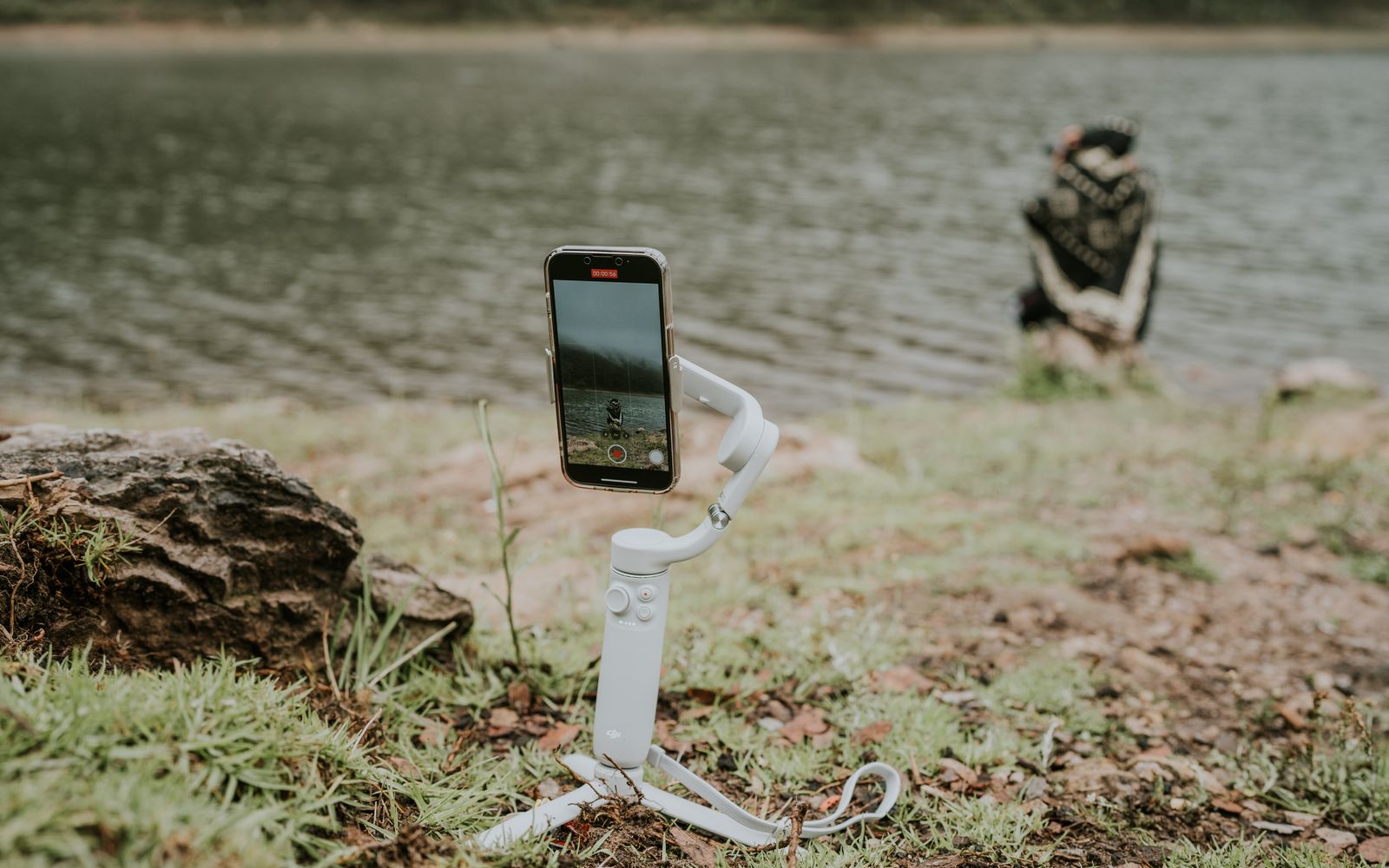 Celular em estabilizador filmando a beira de um lago