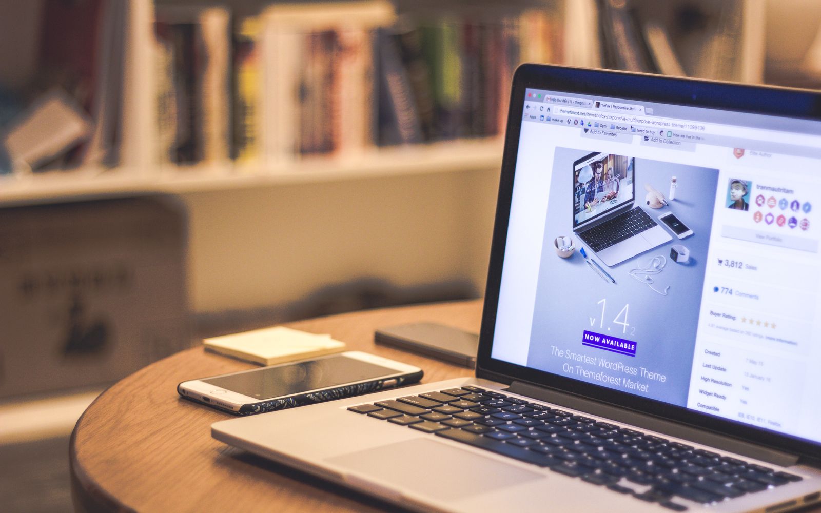 Um ambiente moderno acolhedor com uma mesa de trabalho, um laptop exibindo um site, um smartphone e livros em prateleiras
