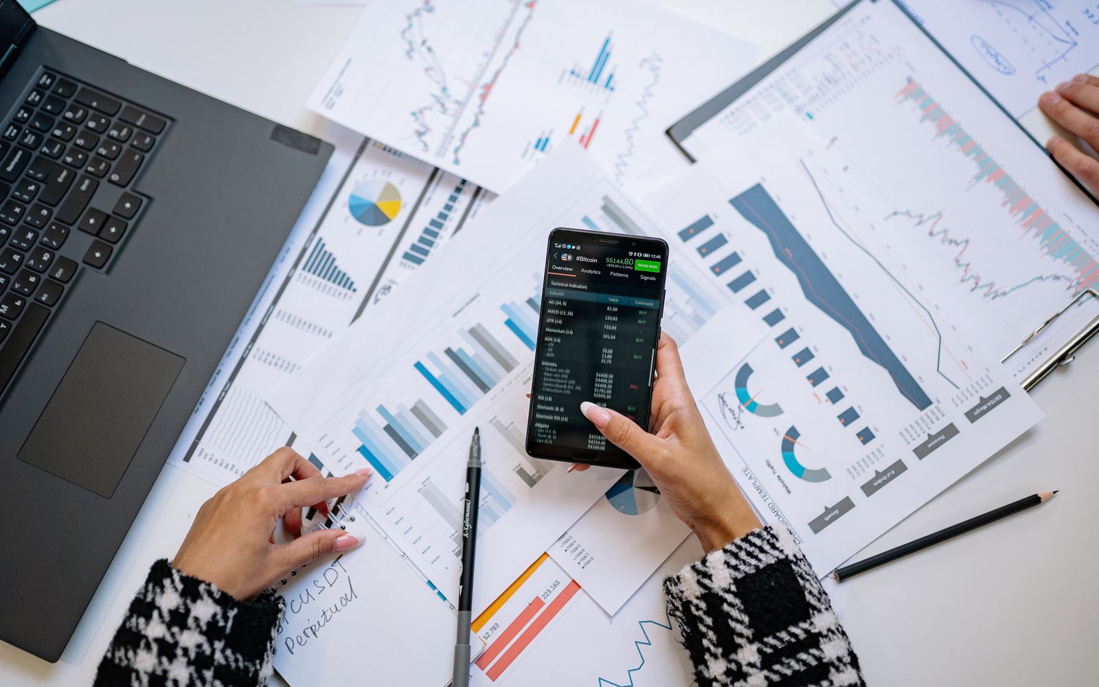 Vista superior de gráficos e smartphone em um escritório, mostrando análise de dados