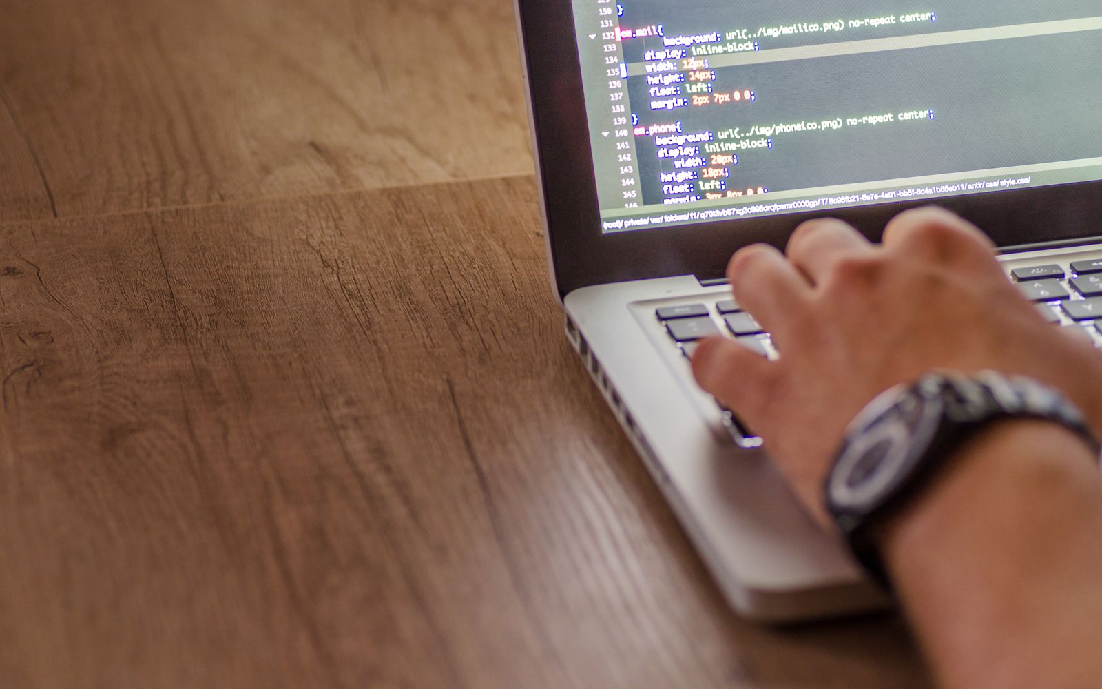 Foto em close de uma pessoa codificando em um laptop, mostrando conceitos de desenvolvimento web e programação