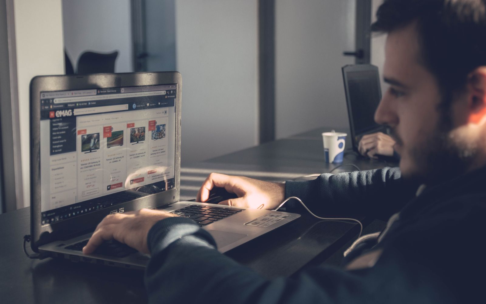 Homem usando notebook para navegar em um marketplace