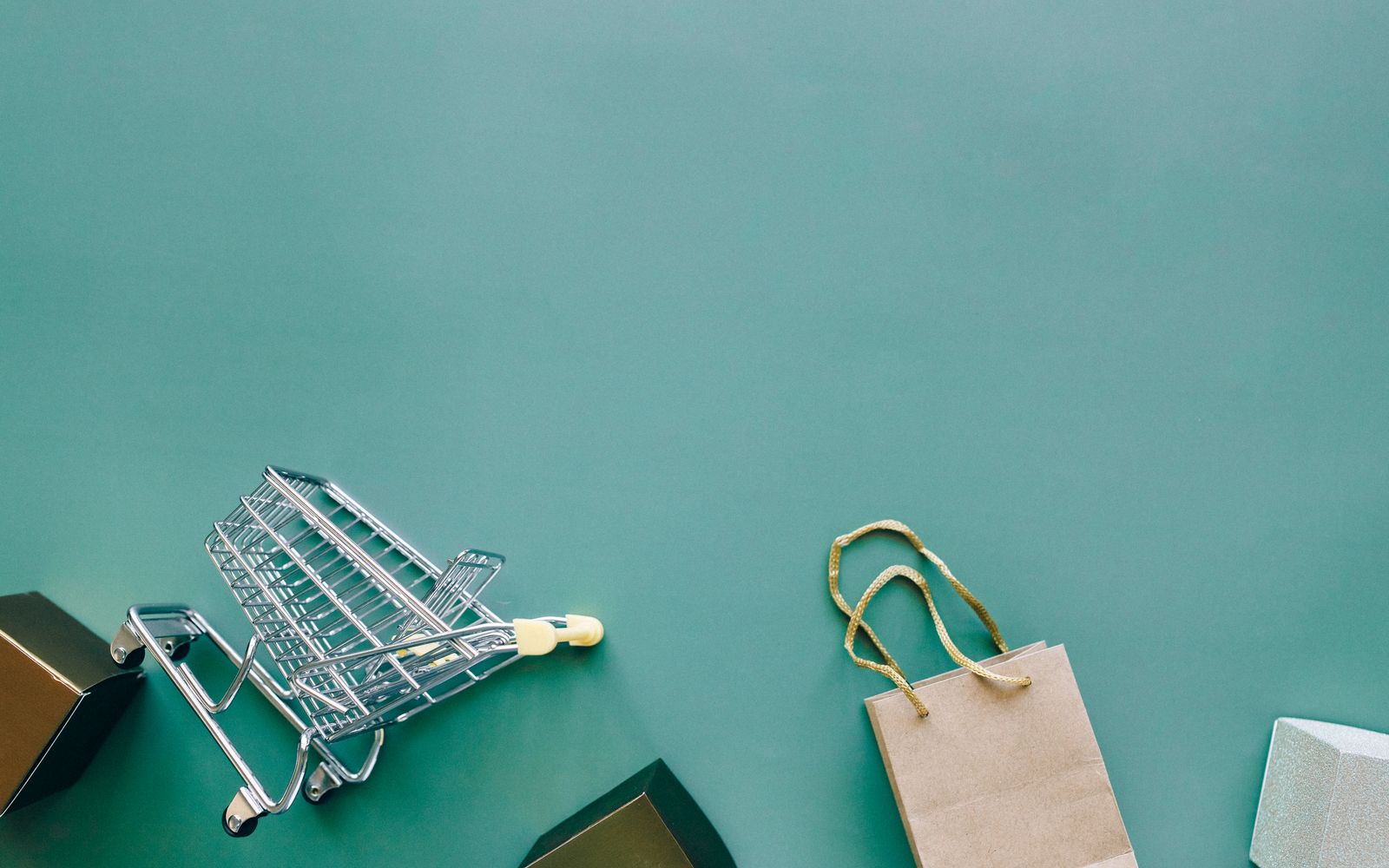 Carrinho e sacola de compras vistos de cima sobre fundo azul