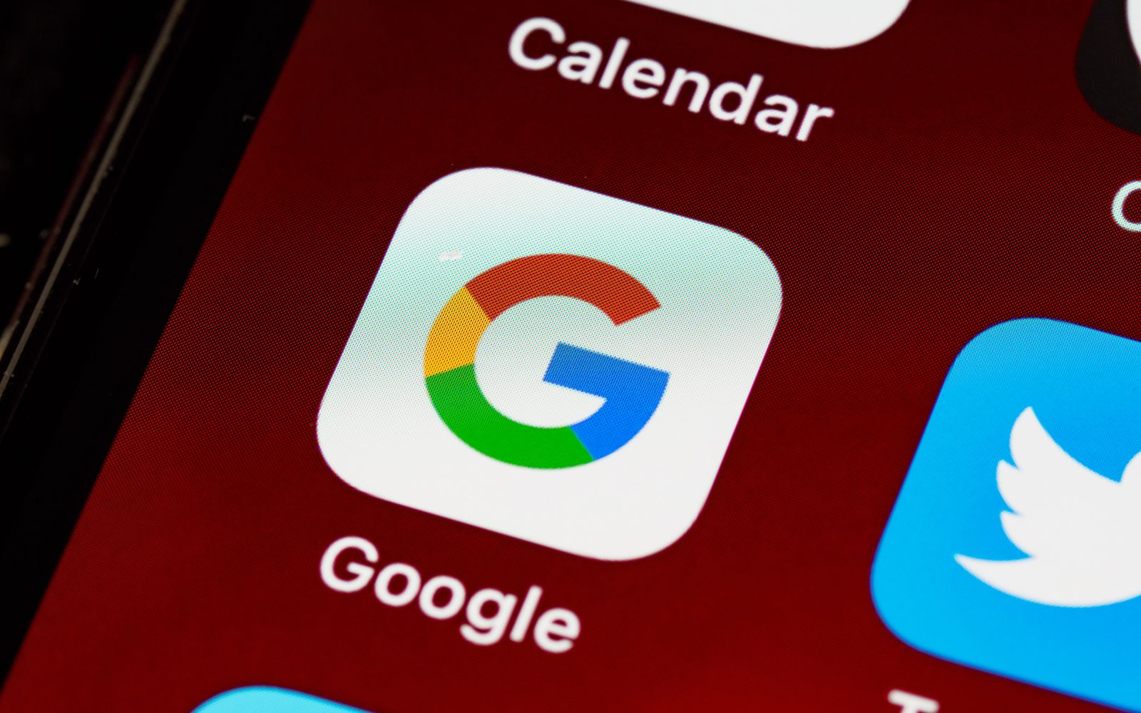 Tela inicial de um celular em macro, com o ícone do Google e outros aplicativos
