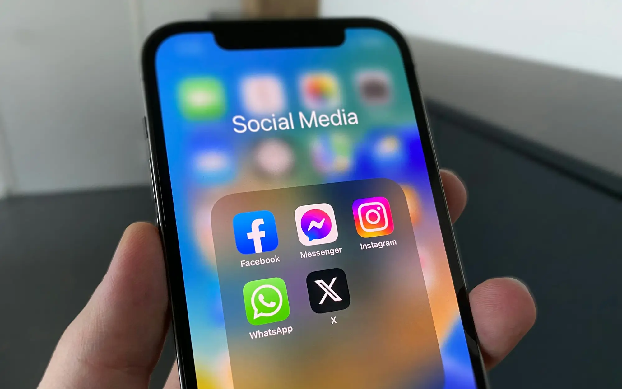 Mão segurando o celular aberto nas redes sociais