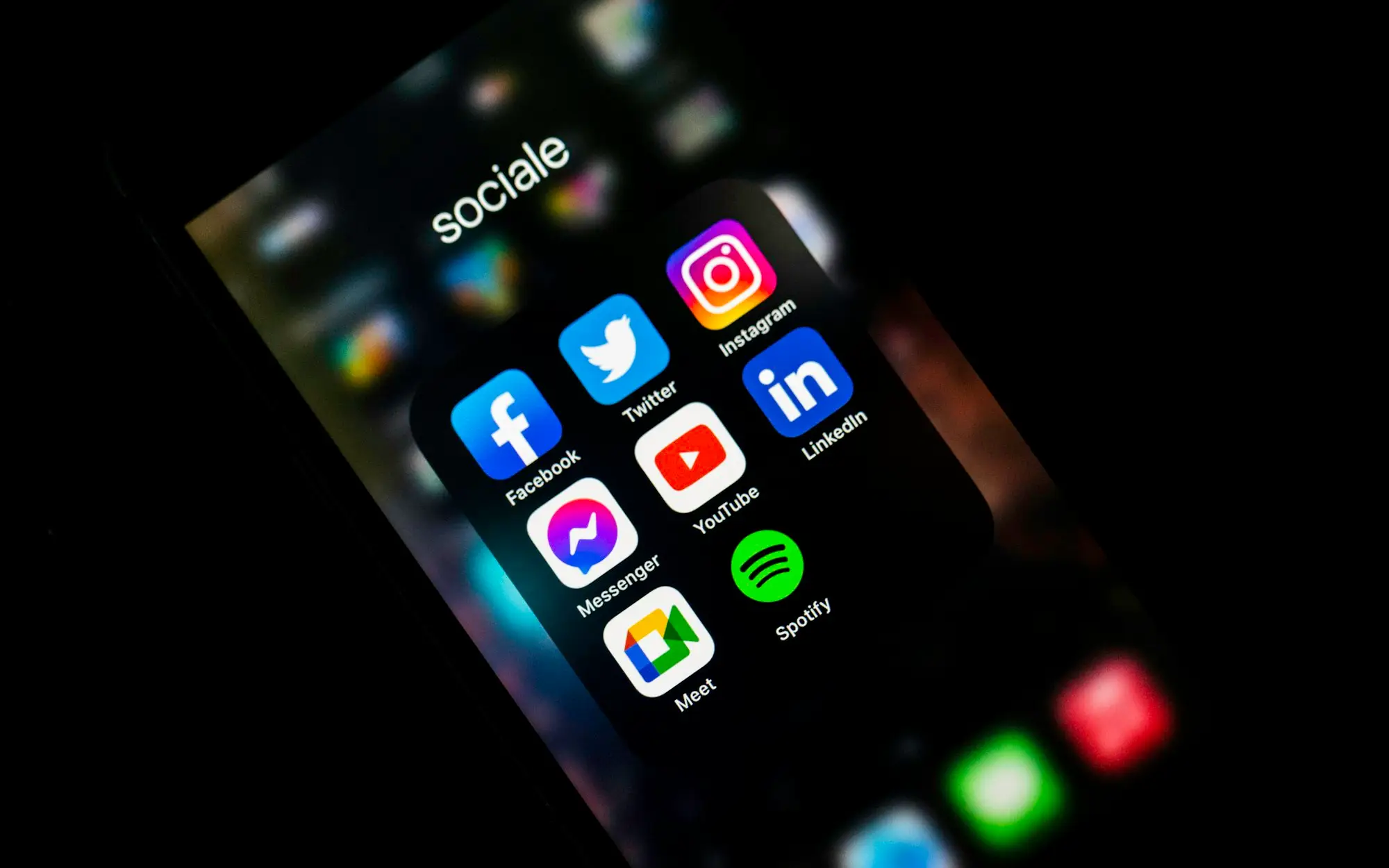 Tela de celular no escuro com os ícones das redes sociais